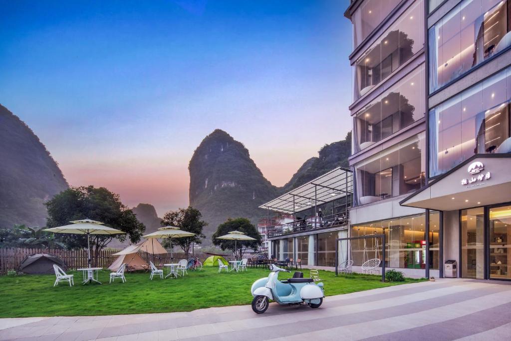 uno scooter parcheggiato di fronte a un edificio di Lanshan Moon Resort a Yangshuo