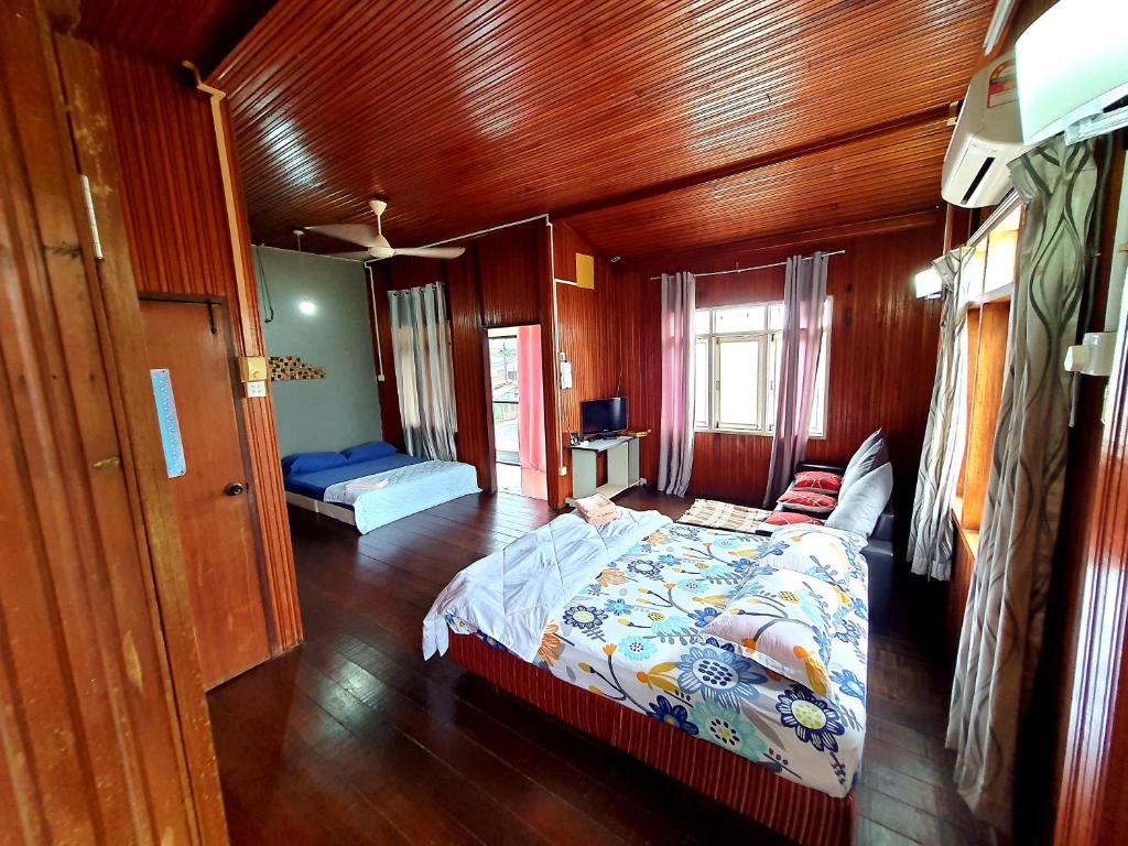 ein Schlafzimmer mit einem Bett in einem Holzzimmer in der Unterkunft Homestay Kuala Terengganu One Stop 1 in Kuala Terengganu