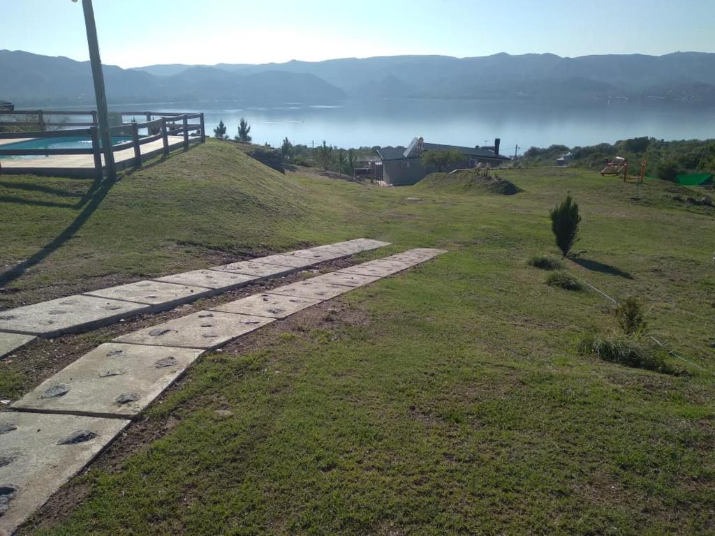 um caminho de pedra numa colina com vista para a água em Lago Belo em Córdoba