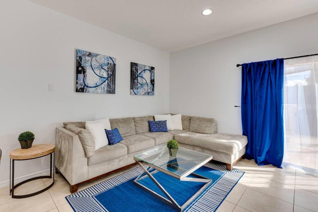 a living room with a couch and a glass table at Welcome to Villa Azul, your home away from home! in Kissimmee