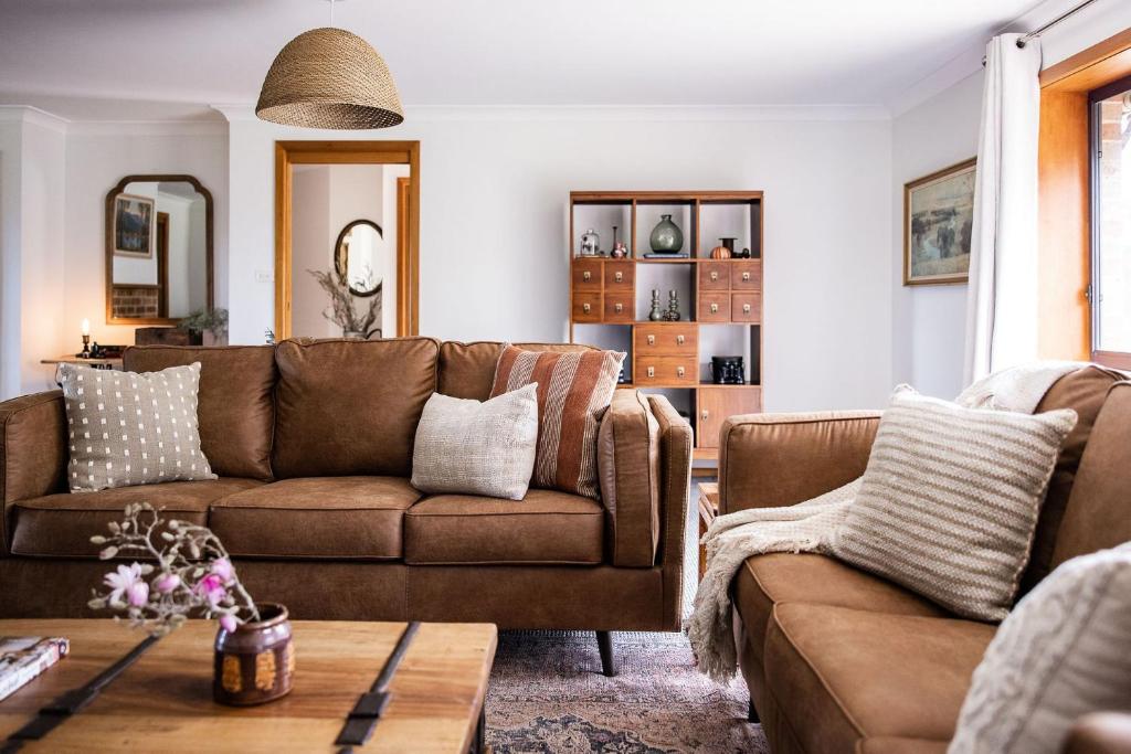 uma sala de estar com um sofá e uma mesa em Little Haven, Jervis Bay em Falls Creek