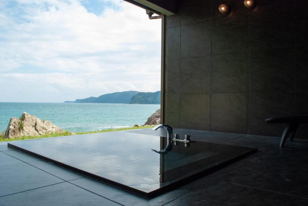 y baño con ducha y vistas al océano. en お宿　弘法湯, en Kushimoto