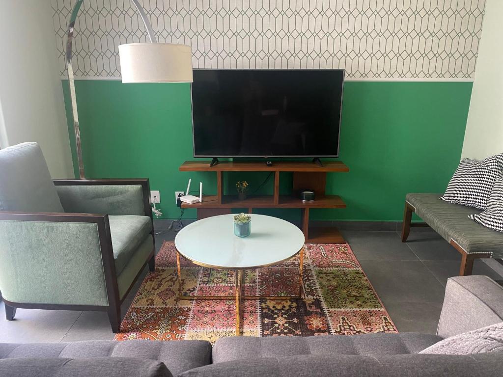a living room with two couches and a tv at ACOGEDOR DEPARTAMENTO en zona de Santa Fé in Mexico City