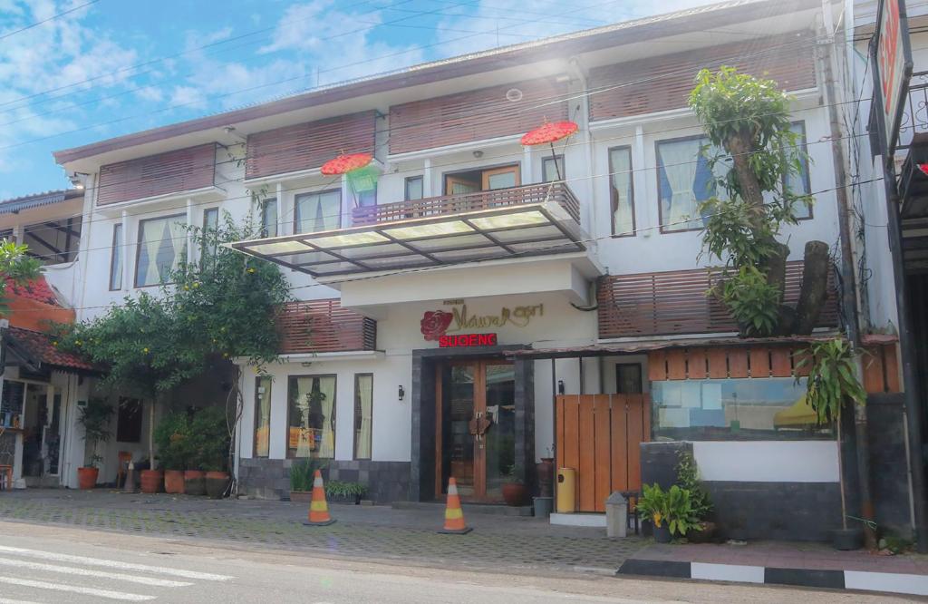 un edificio su una strada con coni arancioni di fronte di Mawar Asri Hotel a Yogyakarta