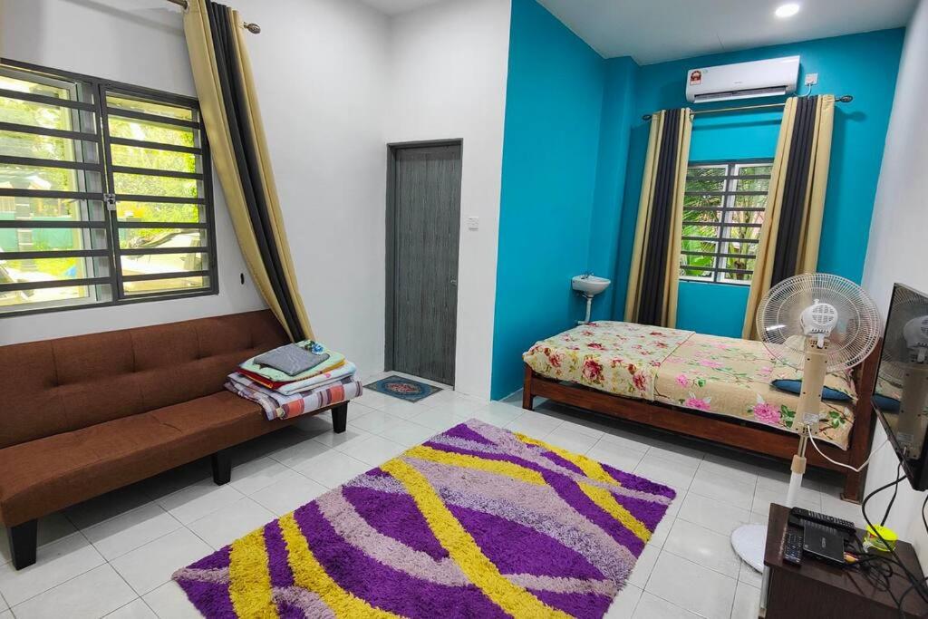 Habitación con sofá, cama y alfombra. en Homestay D Paya Jauh en Temerloh