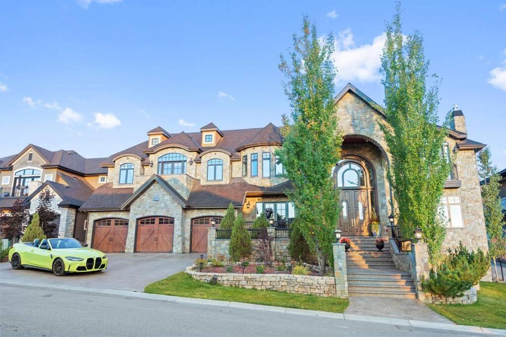 a yellow car parked in front of a large house at French Château w/Swim Spa & Theatre: 11,700 sqft in Calgary