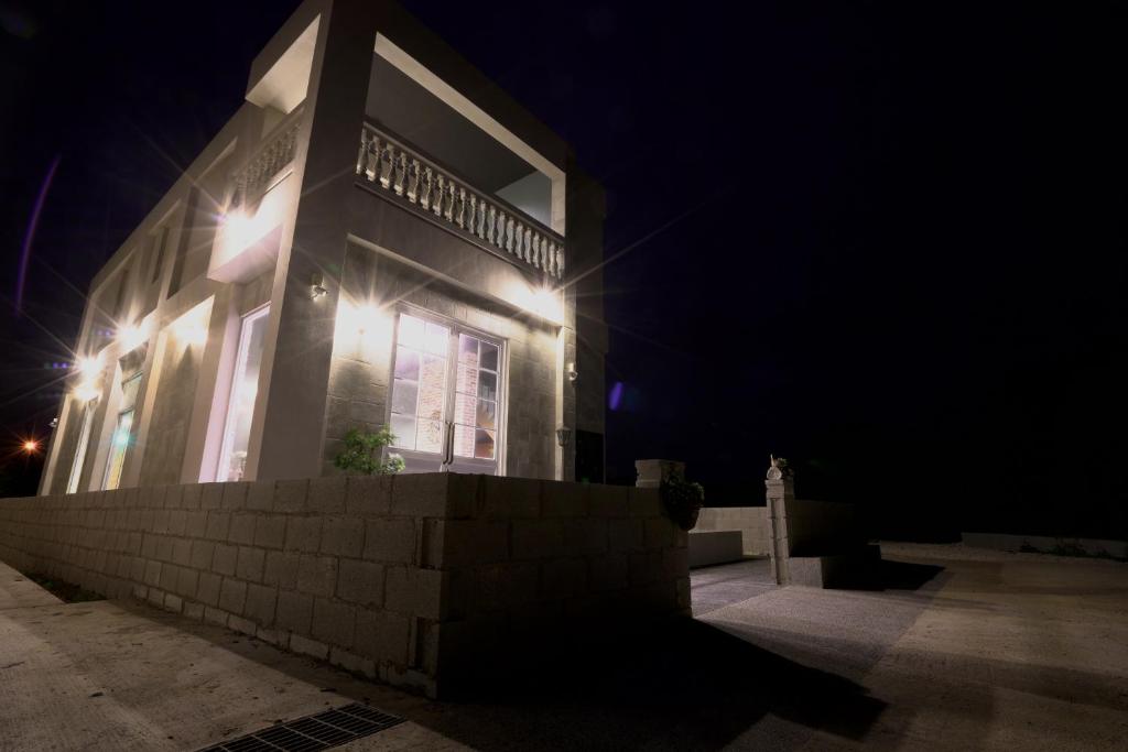 a house with lights on the side of it at night at PENGHU Lucai B&B 旅采民宿 in Magong