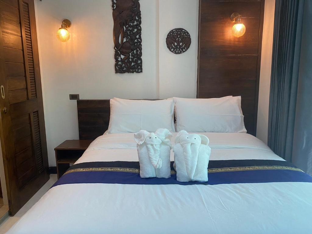 Dois pares de toalhas sentados em cima de uma cama em Lemon Guesthouse em Chiang Mai