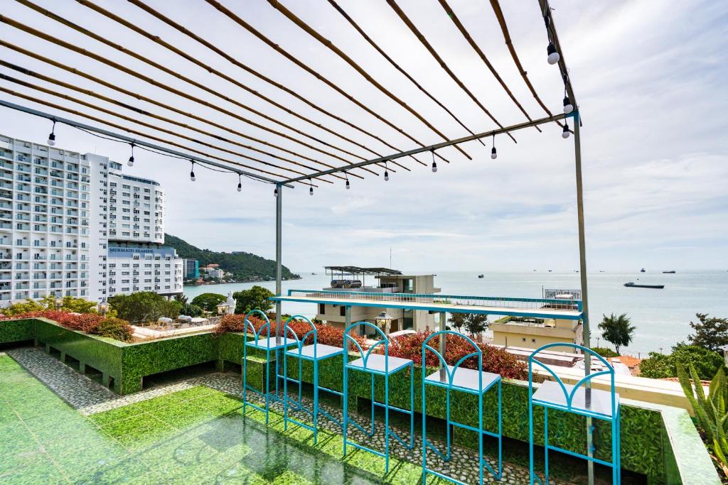 ブンタウにあるSunset Bãi Dâu Boutique Hotel Vũng Tàuの海の景色を望むバルコニー(椅子付)