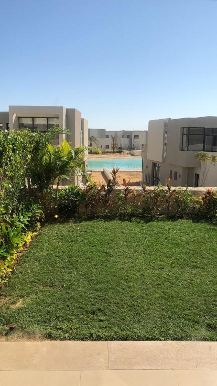 a lawn in front of a building with a beach at Ain Sokhna 'Cosmopolitan'- Half-Board in Ain Sokhna