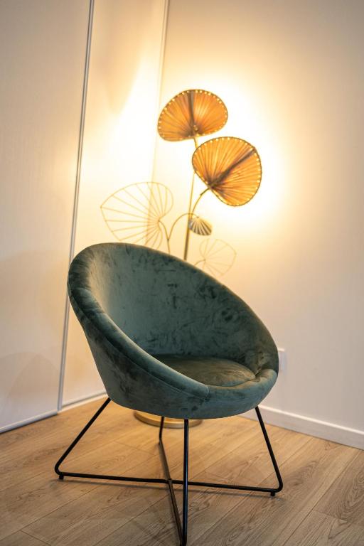 a green chair with umbrellas in a room at Les Granges de Jules in Lafitte-Vigordanne