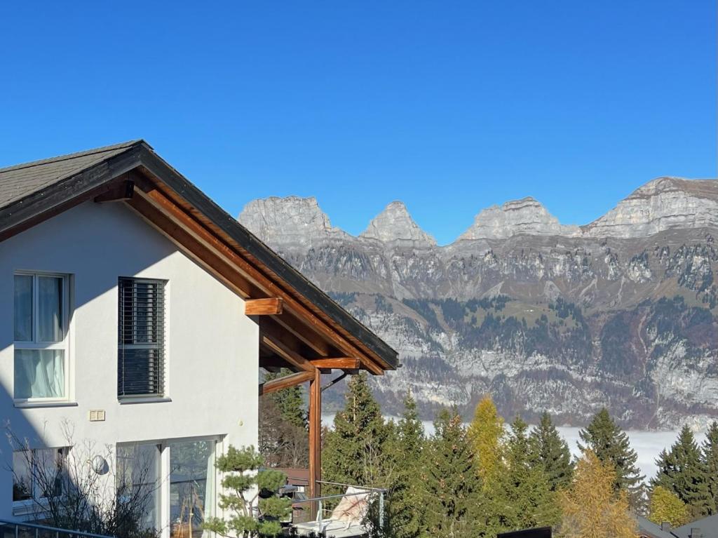 uma casa branca com montanhas ao fundo em The View em Flumserberg