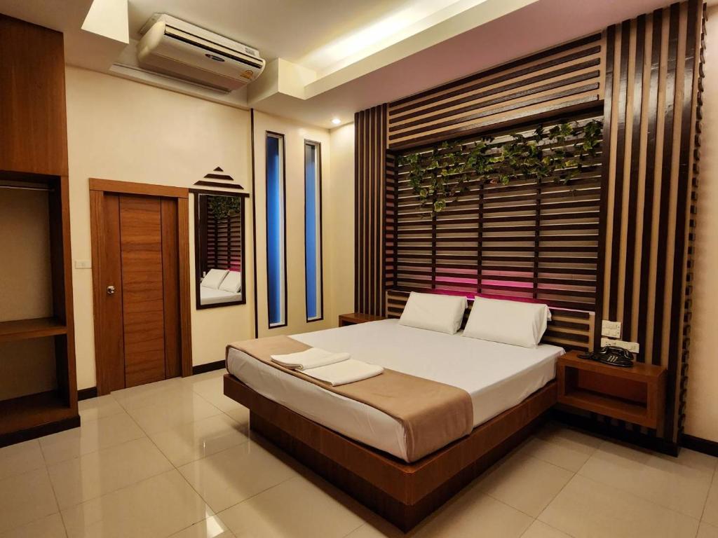 A bed or beds in a room at Hi-End Sriracha Resort & Hotel