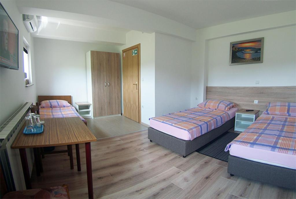 Habitación de hotel con 2 camas y mesa en Sobe Mrak en Bjelovar