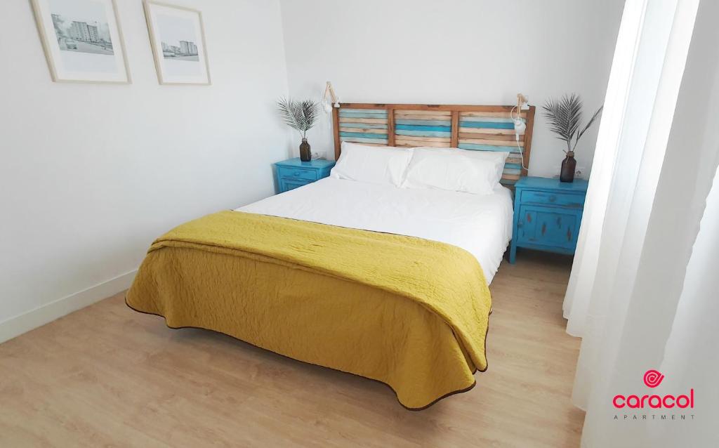 1 dormitorio con 1 cama con manta amarilla y armarios azules en Apartamento Caracol - CORDOBA en Córdoba