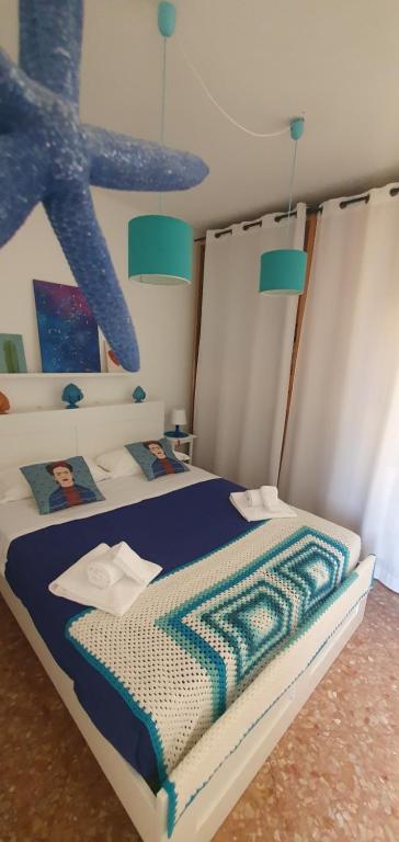 un letto con una coperta blu e bianca sopra di Madò Apartments Egnazia a Bari