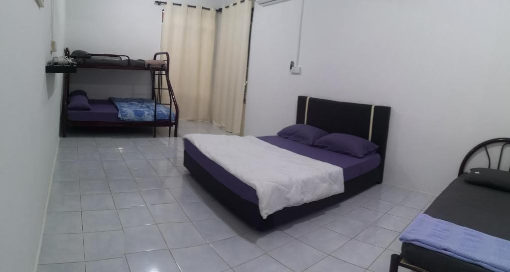 um quarto com uma cama e 2 beliches em E3 Summer Homestay 夏之屋 em Kudat