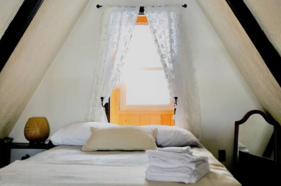 1 dormitorio con 1 cama y ventana grande en Escape in our Rain-Forest A-Frame Cabin-Retreat 1hour from The Pononos, en Harveys Lake