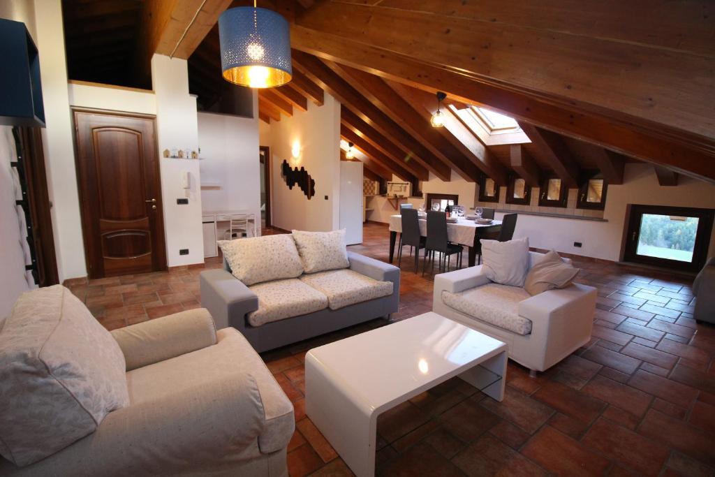 un soggiorno con divani e una sala da pranzo di Attico dell'Aquila a Brusson