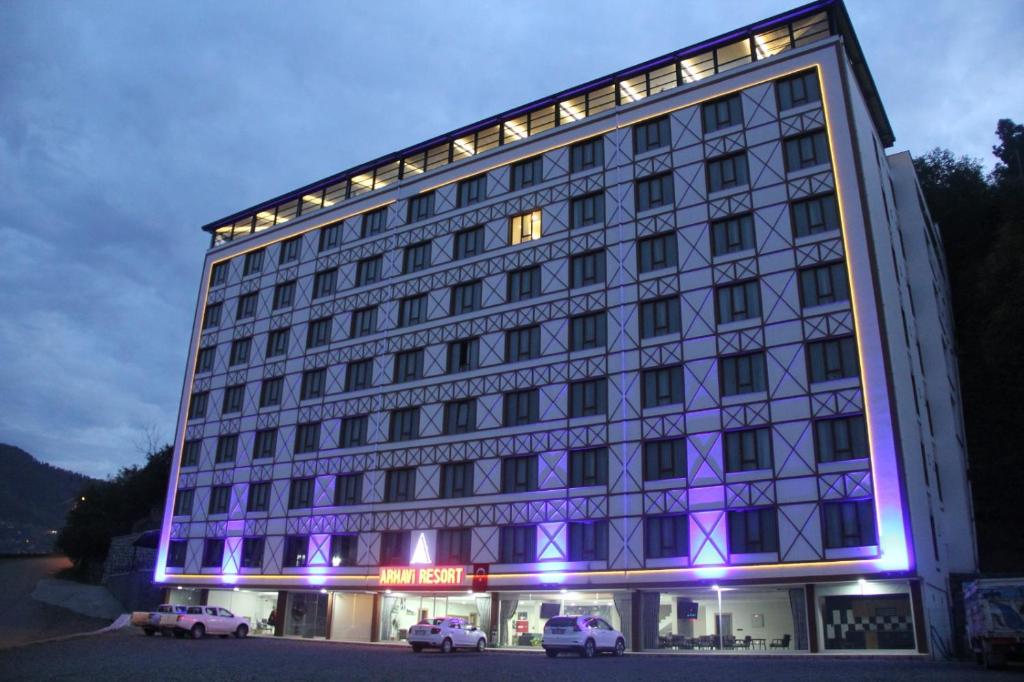 Un bâtiment avec des lumières violettes sur son côté dans l'établissement Arhavi Resort Otel, à Arhavi