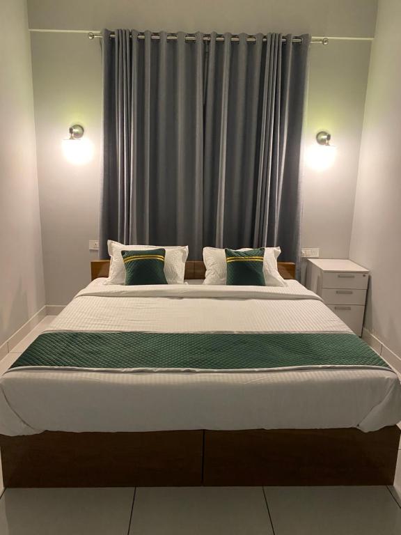 sypialnia z dużym łóżkiem przed oknem w obiekcie HOLLYWOOD Rooms w mieście Sultan Bathery