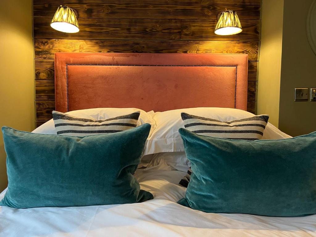 Una cama con dos almohadas azules encima. en East Beach Guest House, en Littlehampton