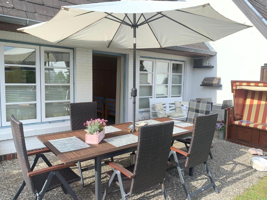 un tavolo in legno con ombrellone su un patio di Westwind a Westerland
