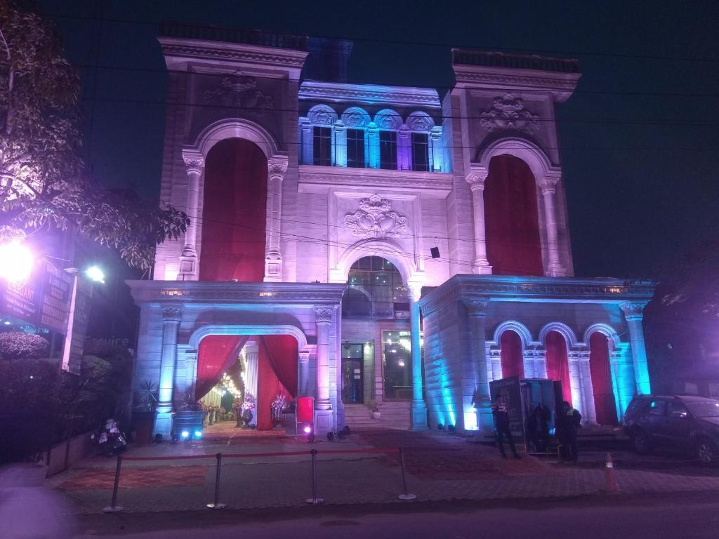 a building is lit up in blue and red at L'ELEGANT Hotel & Banquet in Ghaziabad