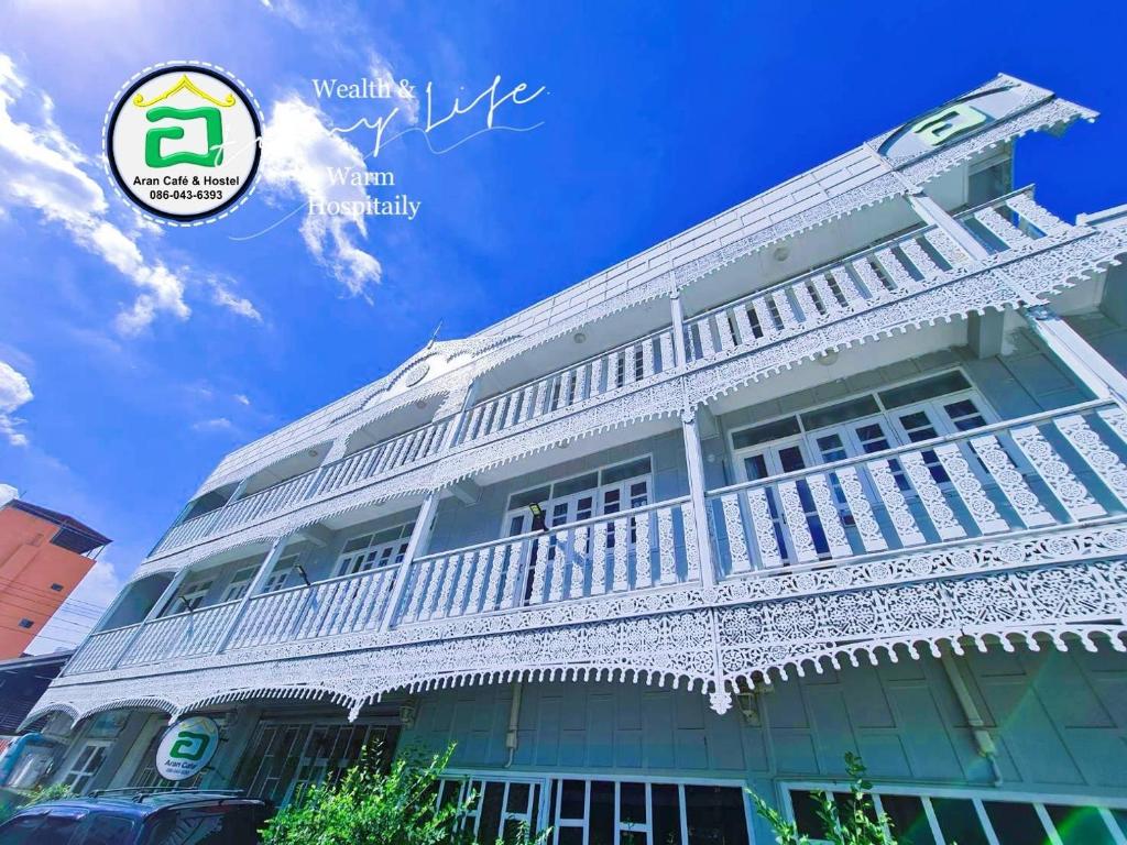 a white building with a balcony on top of it at AranHostel&Cafe in Ban Bang Khen (1)