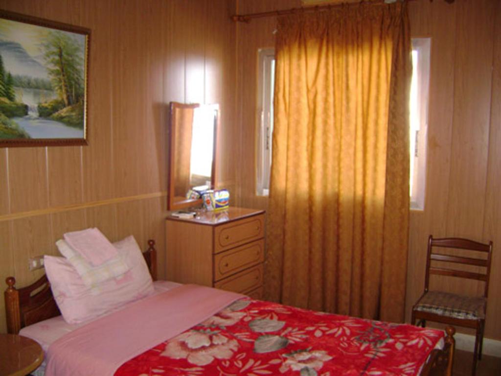 Un pat sau paturi într-o cameră la Regis Hotel