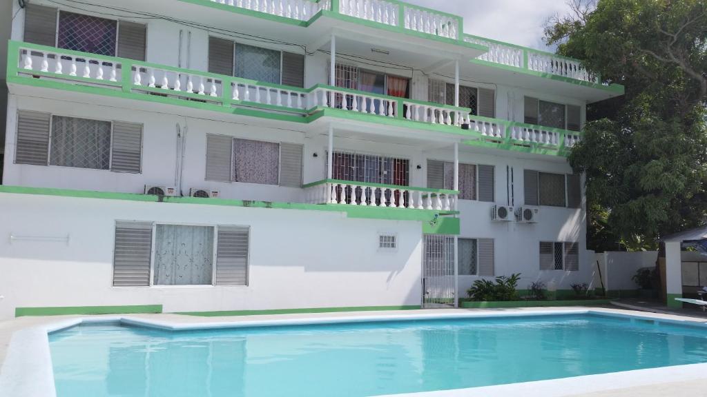 an apartment building with a swimming pool in front of it at Villa Donna Inn in Montego Bay