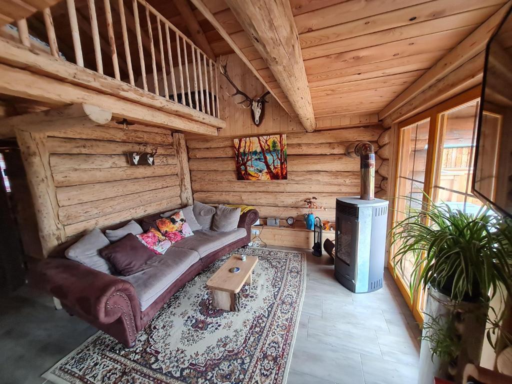 uma sala de estar com um sofá e um fogão em Naturstammhaus-Blockhaus em Klagenfurt