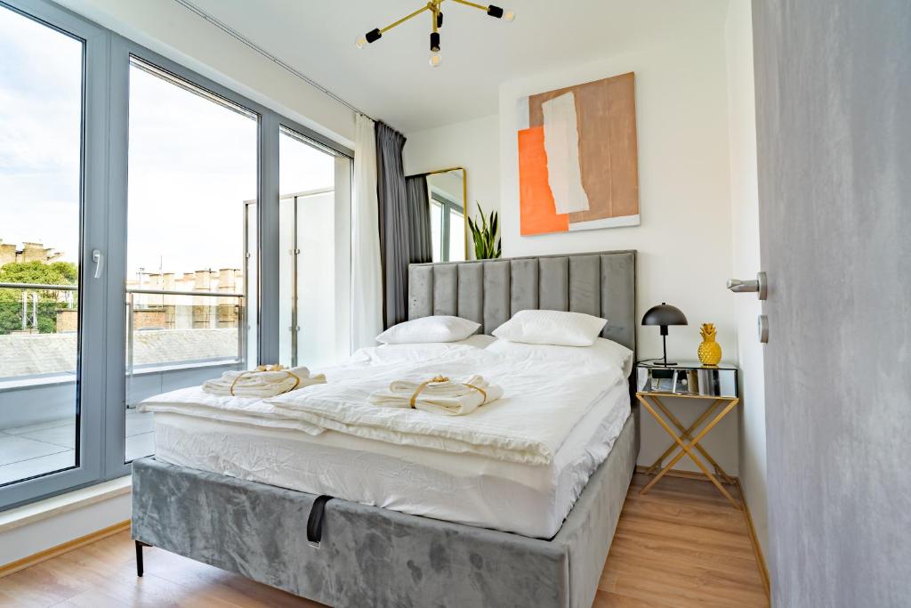um quarto com uma cama grande e uma janela grande em Central Apartment Budapest ~ Roof Terrace/AC/Indoor parking em Budapeste