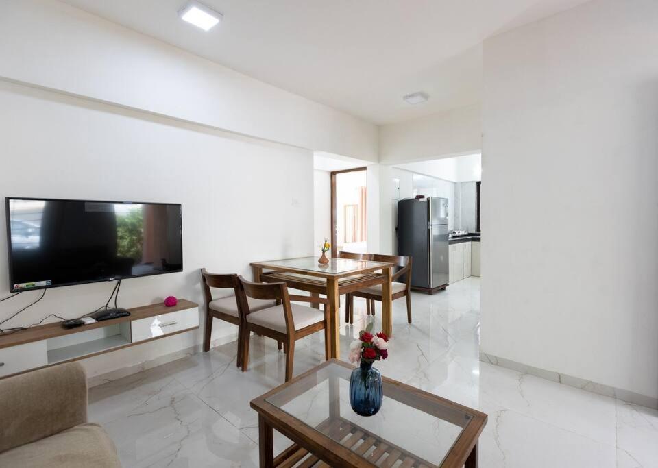 a living room with a couch and a table and a tv at Lotus 3BHK by SoulStays in Dapoli
