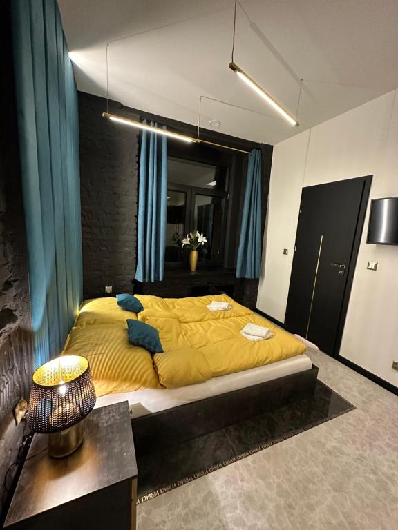 a bedroom with a large yellow bed in a room at DarkHouse Versace Blue in Łódź