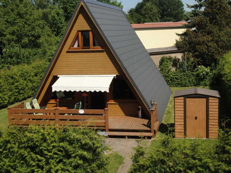 ein kleines Haus mit einem Gamer-Dach und einer Veranda in der Unterkunft Finnhütte Cathleen Schulz in Eldena