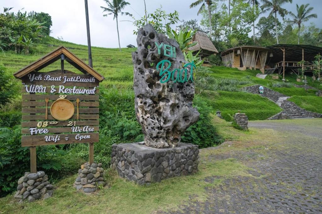 a sign and a statue in front of a resort at Yeh Baat Jatiluwih by The Lavana in Jatiluwih