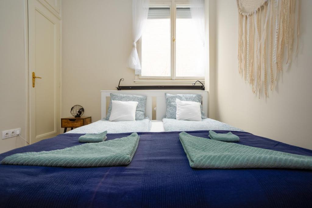 uma grande cama azul com duas almofadas em Golden Hour Apartment em Budapeste