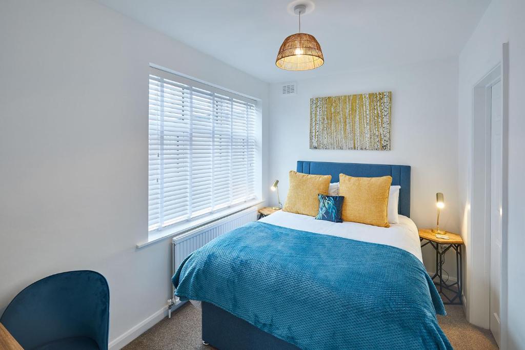 een blauwe en witte slaapkamer met een bed en een raam bij Host & Stay - West Crescent Apartments in Darlington