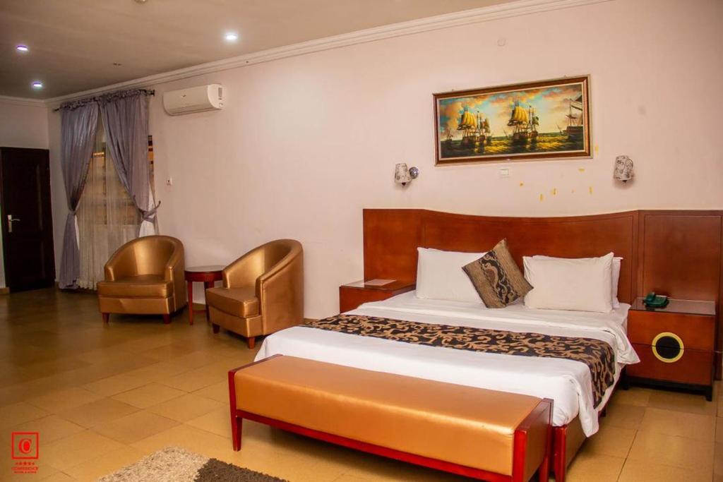 a hotel room with a bed and a chair at Conference Hotel & Suites Ijebu in Ijebu Ode