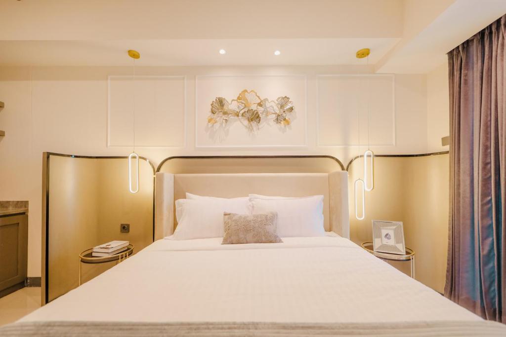 1 dormitorio con 1 cama grande con sábanas blancas en Yoonah at Benson Pakuwon Mall en Lontar