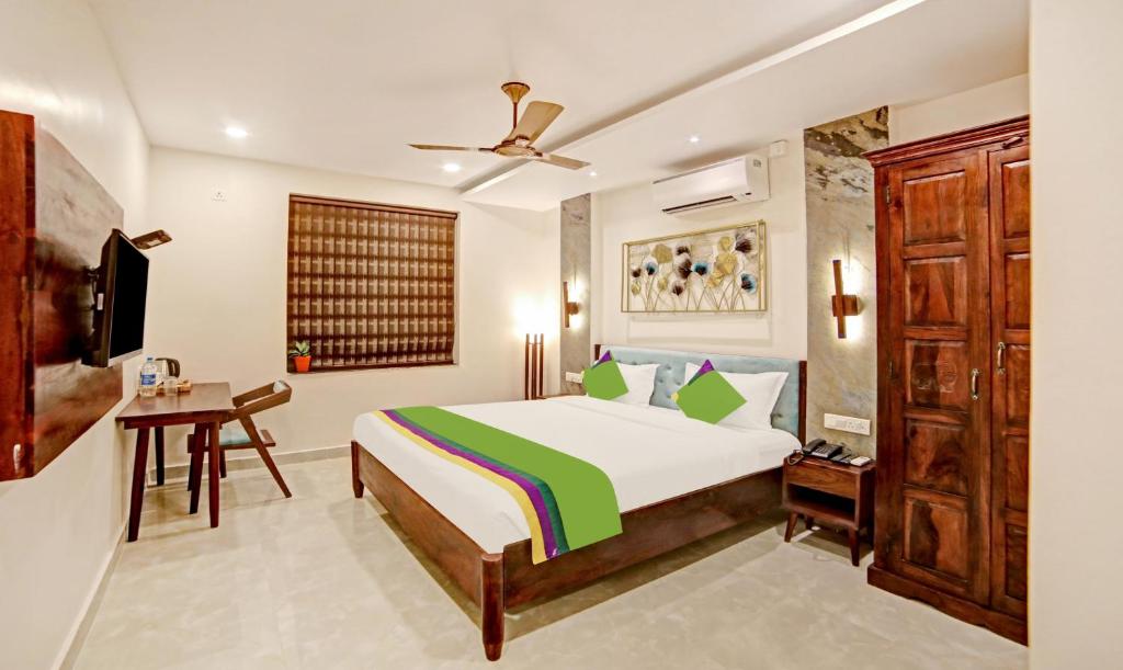 a bedroom with a bed and a desk and a television at Treebo Trend Lazystay Elite in Bhubaneshwar