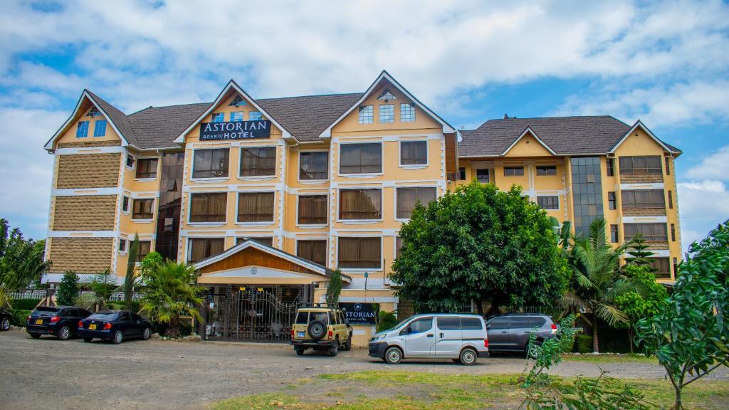 a hotel with cars parked in front of it at Astorian Grand Hotel Naivasha in Naivasha