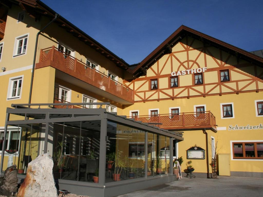 ein großes gelbes Gebäude mit einem Schild drauf in der Unterkunft Hotel Gasthof Schweizerhaus in Stuhlfelden