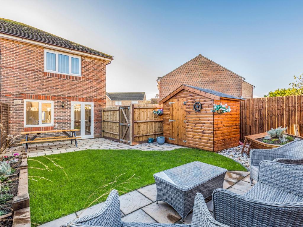 a backyard with a patio with chairs and a fence at Pass the Keys Holiday Home Near Beaches in Chichester
