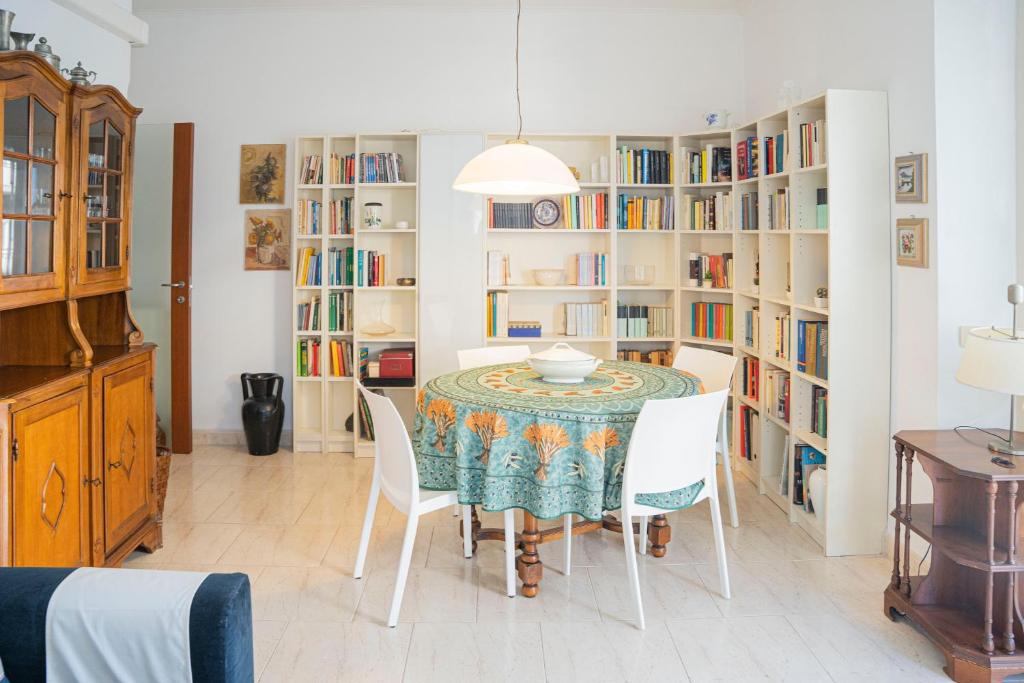 uma sala de jantar com mesa, cadeiras e estantes em 076 - Casa La Libreria, Centro città di Chiavari, 500 metri da mare e spiagge - 2 CAMERE DA LETTO em Chiavari