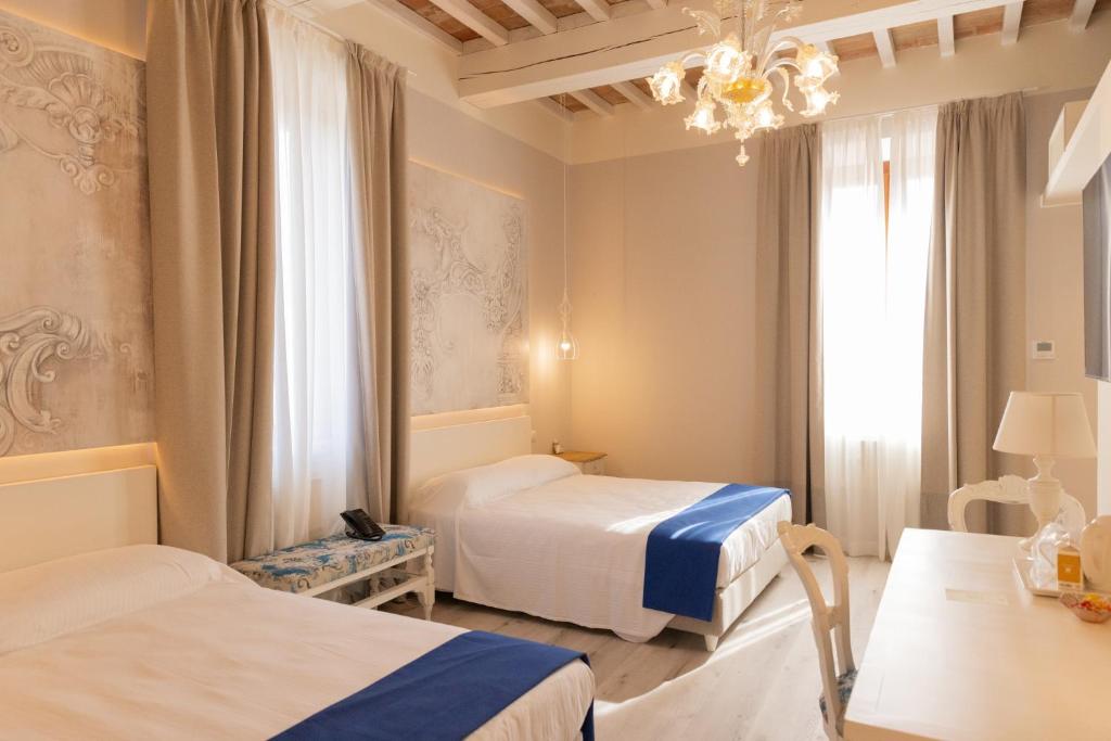Habitación de hotel con 2 camas y lámpara de araña. en Villa La Personala, 