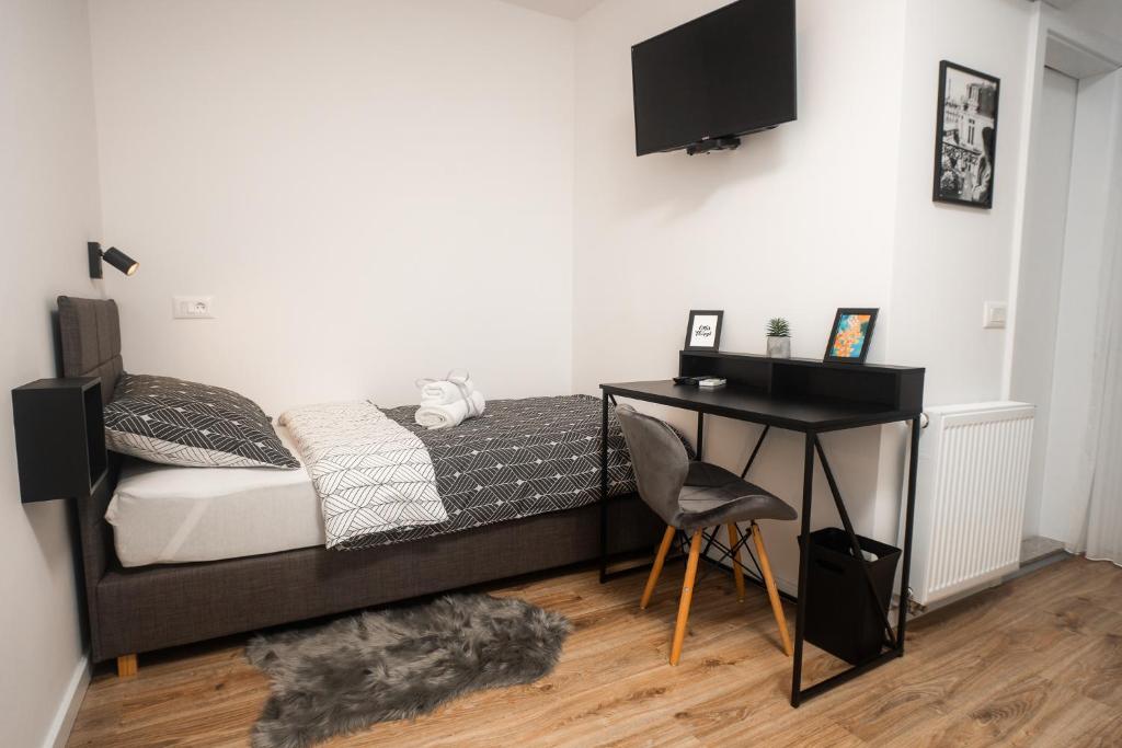 a bedroom with a bed with a desk and a television at LaRoom - Free Parking in Zagreb