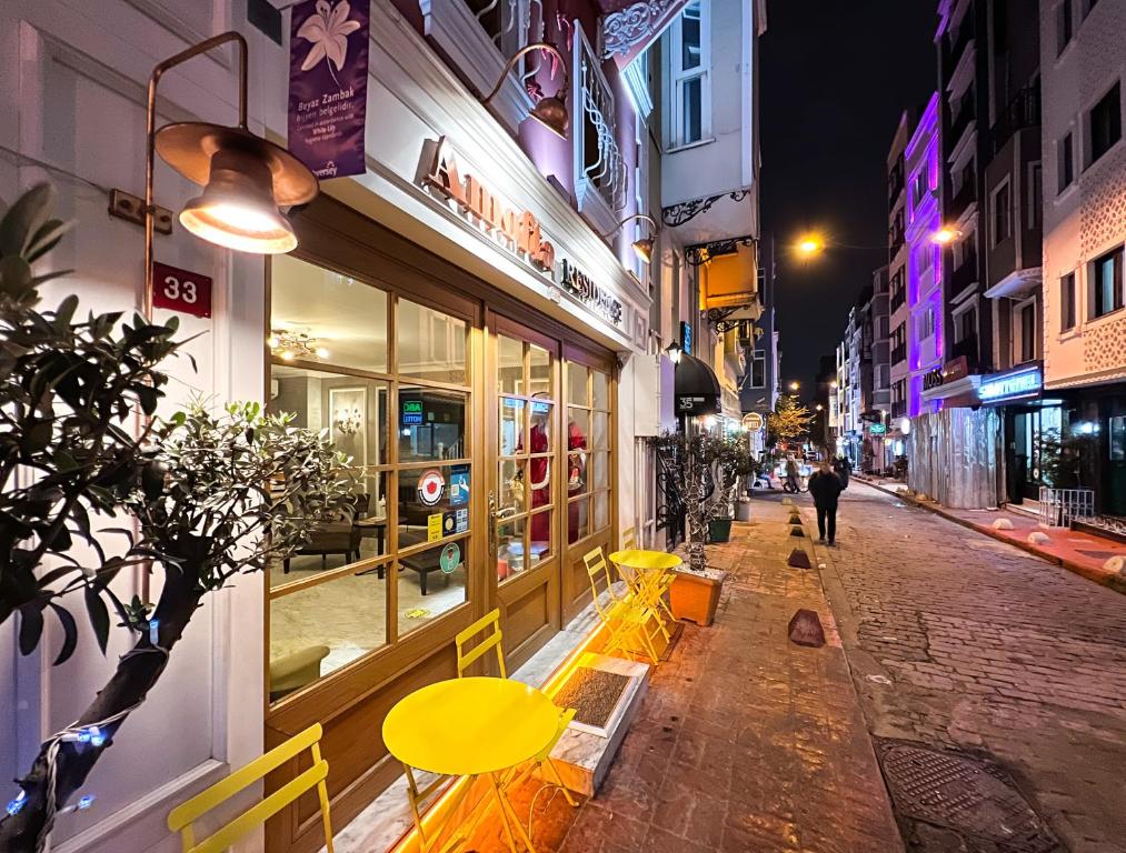 a city street at night with a yellow table and chairs at Amofta Hotel Taksim in Istanbul