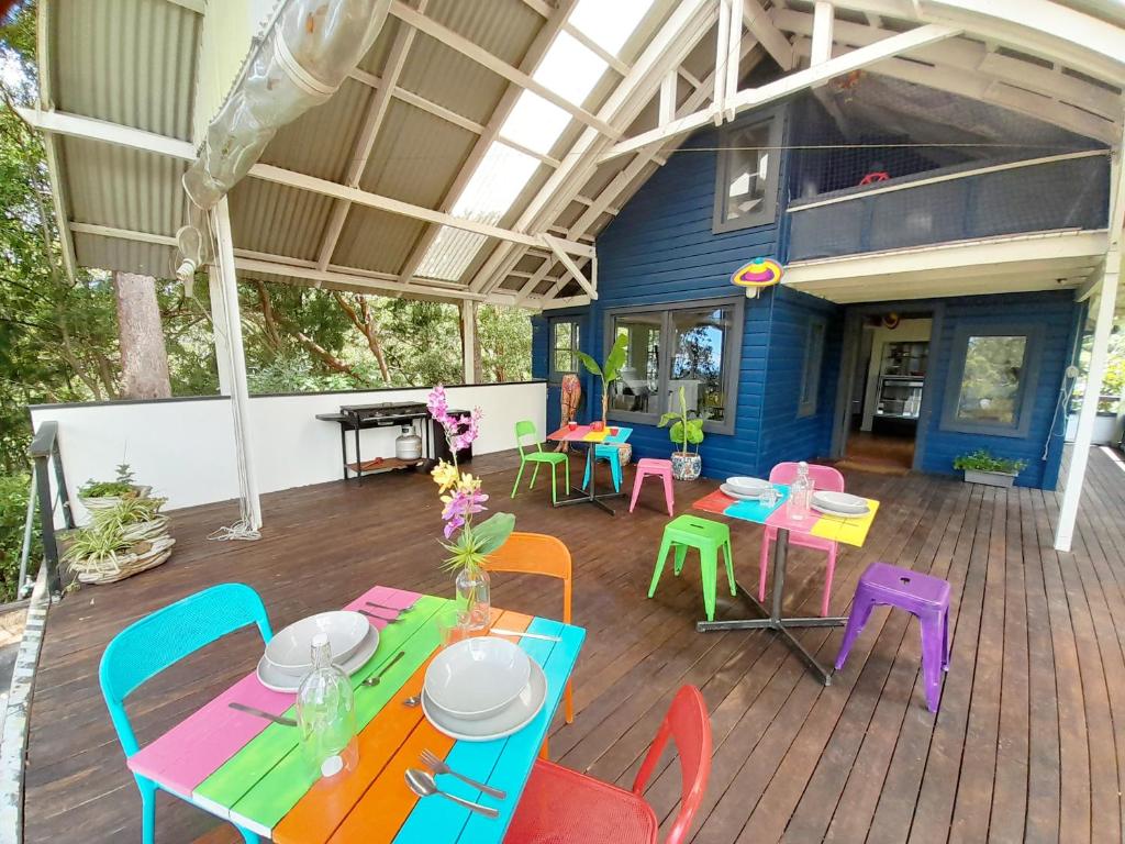 a patio with colorful tables and chairs on a deck at Sky Island Studios in Mount Tamborine
